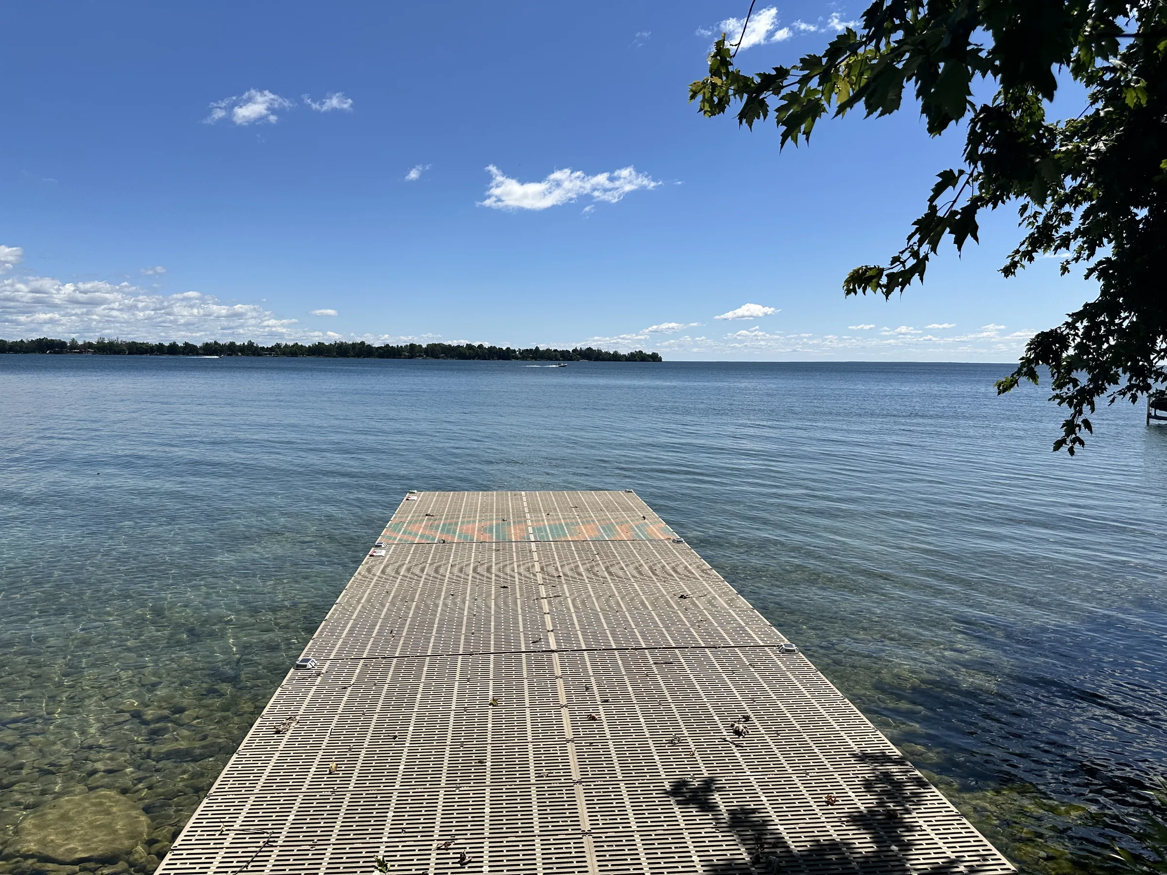 Landscape view from a private dock over the clear water of Lake Simcoe at Bonnie Beach, Ramara, Ontario