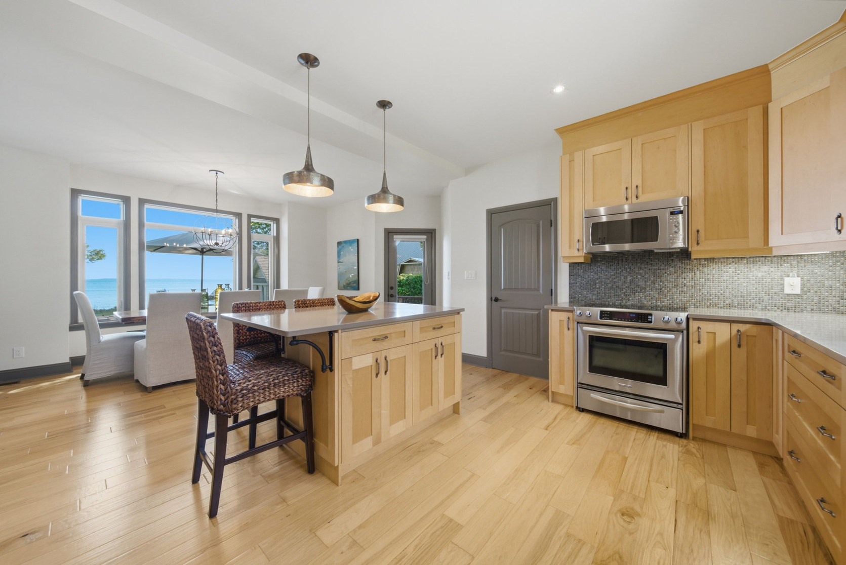 Kitchen at 797 Woodland Drive with a centre island, open to a dining area with a Lake Simcoe view