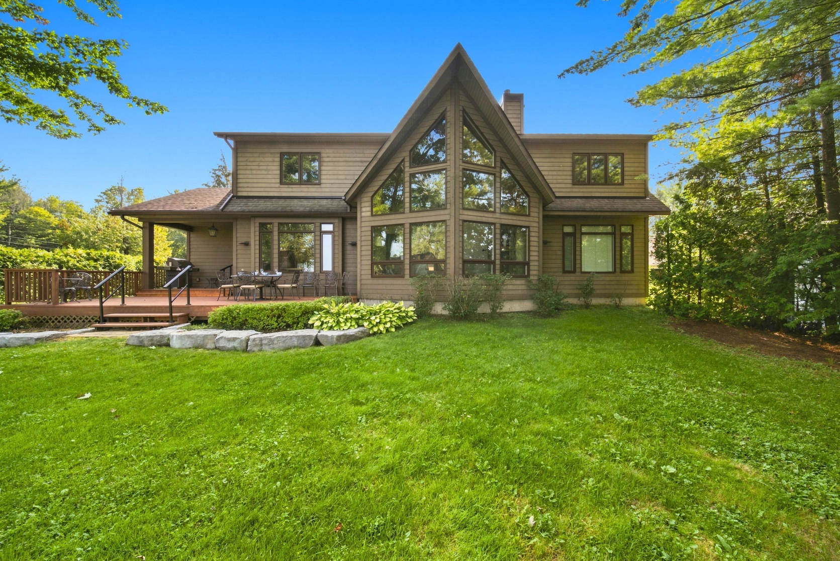 Lake-facing elevation of 797 Woodland Drive with its two-storey window gable and full-width deck