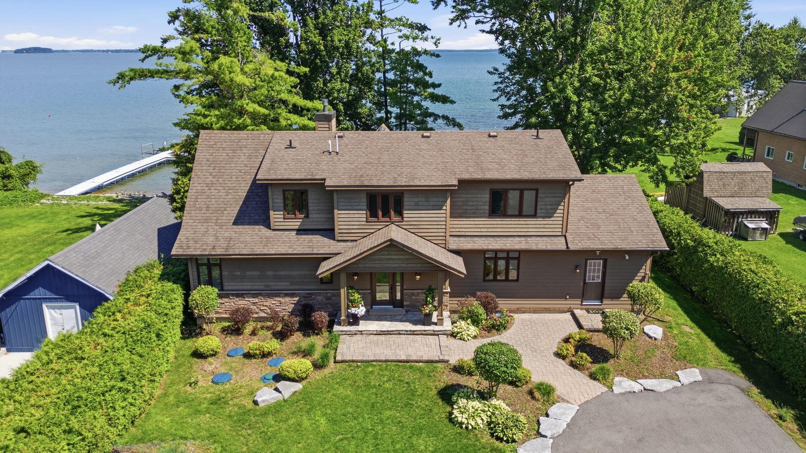 Aerial view of 797 Woodland Drive, Oro-Medonte, showing the house, front drive, shoreline and dock on Lake Simcoe